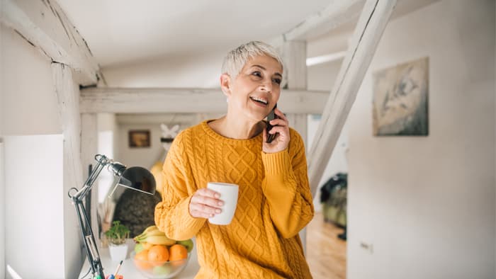 Happy mature woman talking on the phone and smiling.