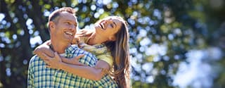 Couple laughing outside on a summer day.