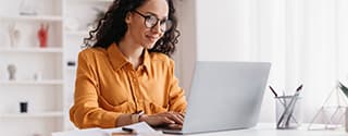Businesswoman sitting in an office with a laptop.