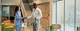 Commercial real estate agent meeting businessman in a modern office building.