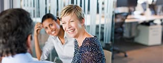 Women smiling in business meeting.