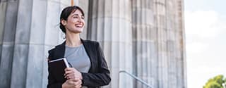 Businesswoman standing in front of government building columns.