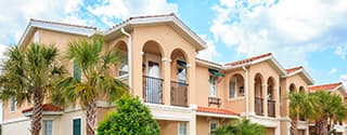 Senior housing building with tropical trees on a sunny day.