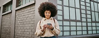 Woman using her cellphone while out in the city.