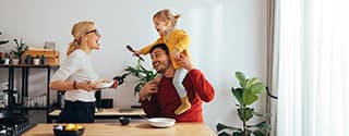 Una familia jugando en la cocina mientras preparan alimentos.