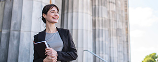 Businesswoman standing in front of government building columns.