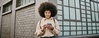 Woman using her cellphone while out in the city.