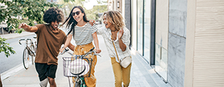 Friends walking down the street with bikes.
