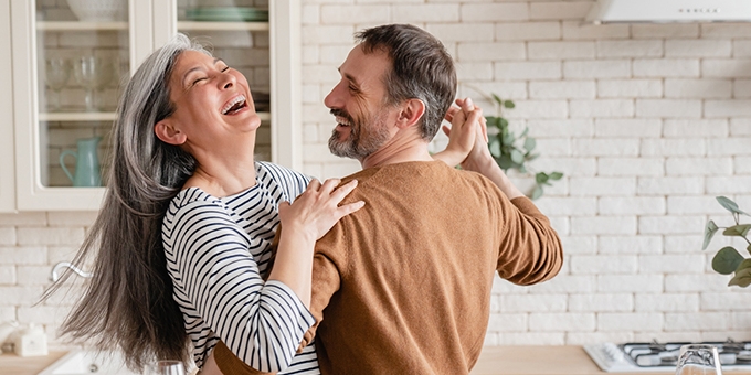 Feliz pareja bailando juntos en la cocina.
