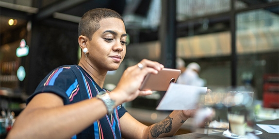 Woman depositing check with a mobile phone.