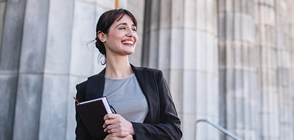 Businesswoman standing in front of government building columns 