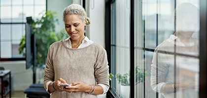 Businesswoman in office checking her mobile phone.
