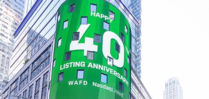 WaFd employees in Times Square NYC with WaFd Nasdaq sign