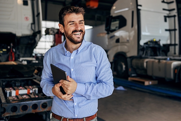 Smiling chief standing in auto park and holding tablet