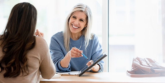 Two businesswomen reviewing a document on a tablet.