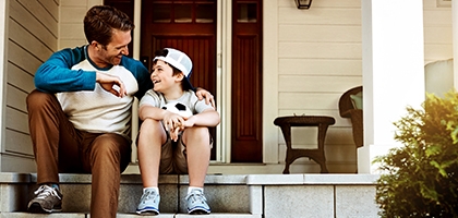 Father and his son laughing and talking on their porch at home