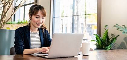 Businesswoman working on laptop at office desk.