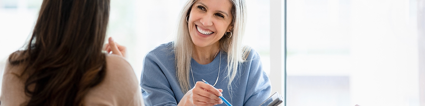 Two businesswomen reviewing a document on a tablet.