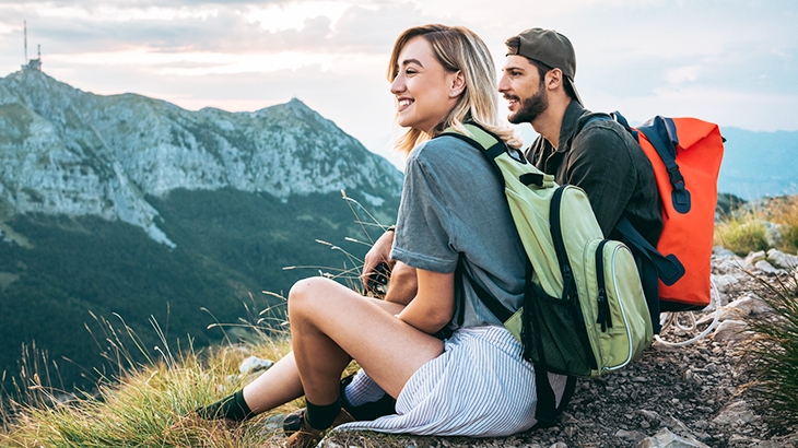 Young couple of hikers enjoying the beautiful nature from high above.