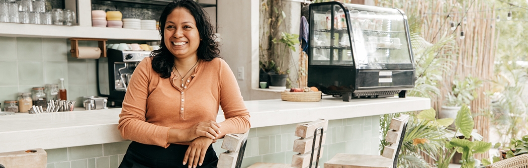 Business owner sitting at cafe bar stool.