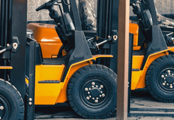 Yellow Forklifts parked in a row in a warehouse