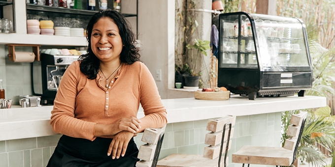 Business owner sitting at cafe bar stool.