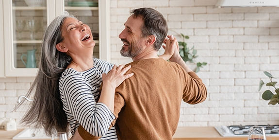Feliz pareja bailando juntos en la cocina.