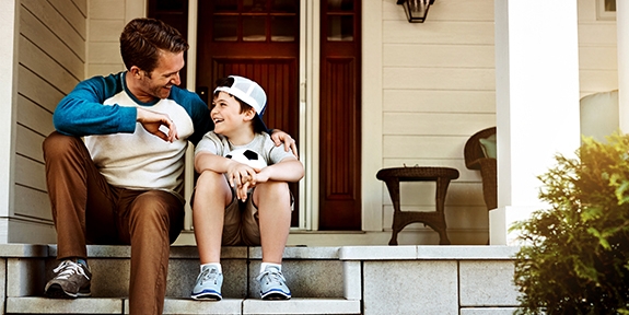 Father and his son laughing and talking on their porch at home