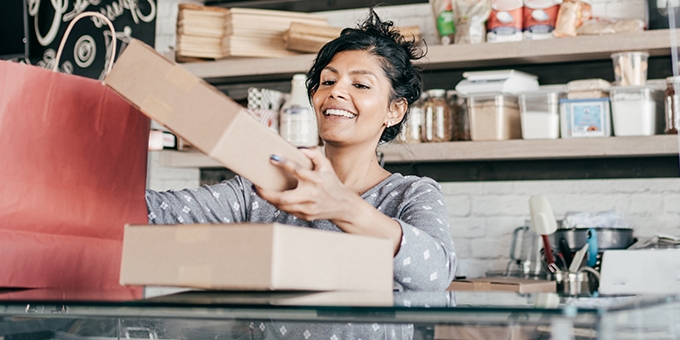 A young business owner packaging products.