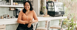 Business owner sitting at cafe bar stool.
