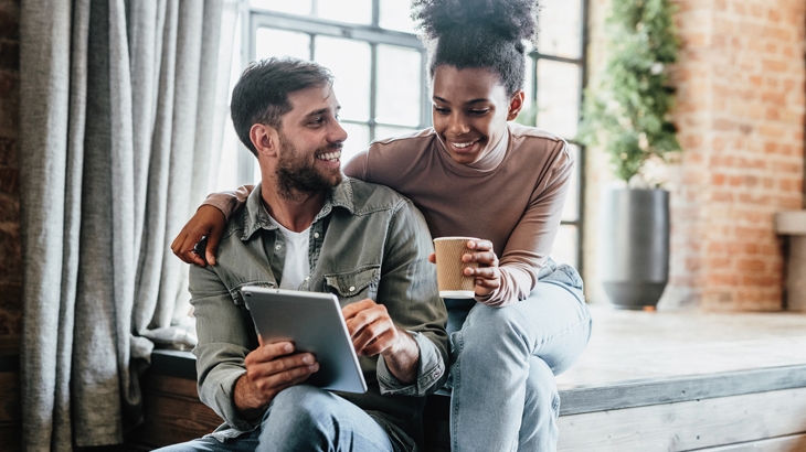 Couple in their new modern loft using tablet.