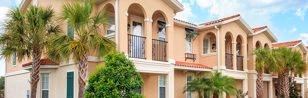 Senior housing building with tropical trees on a sunny day.