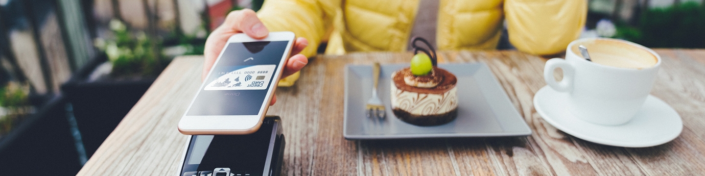 Woman paying for dessert with digital debit card mobile pay.