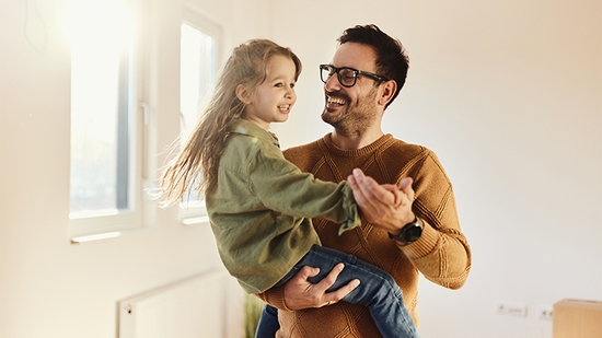 Padre sosteniendo a su pequeña hija y bailando.