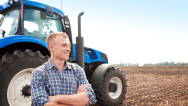 Farmer standing in front of a tractor