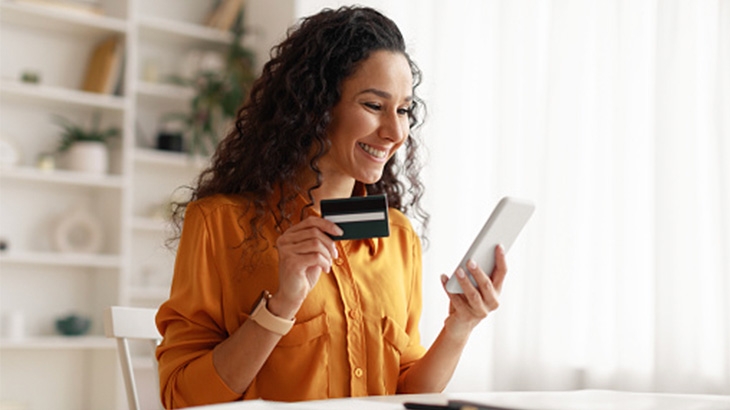 Businesswoman using a WaFd credit card for online shopping.