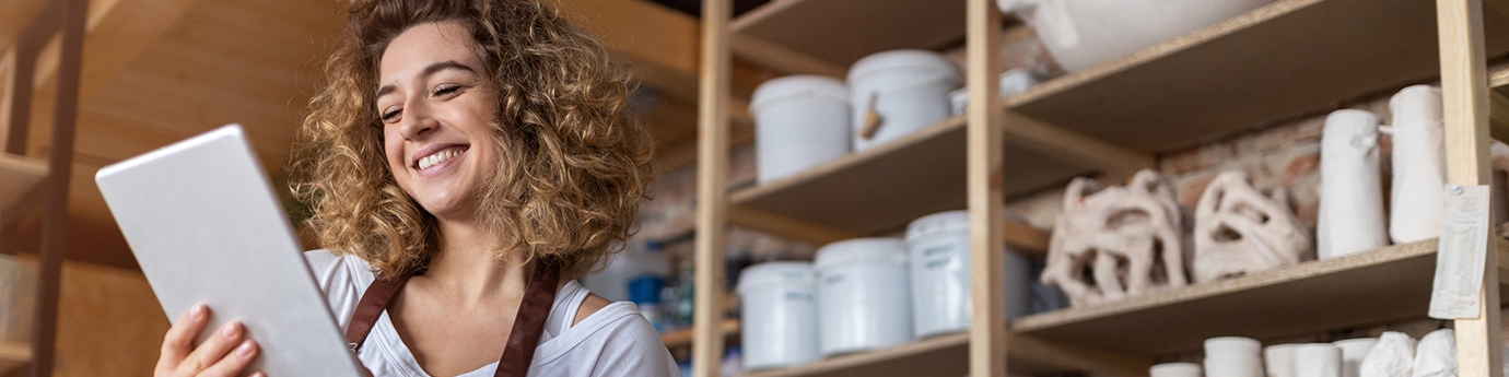 Craftswoman with tablet in her art studio.