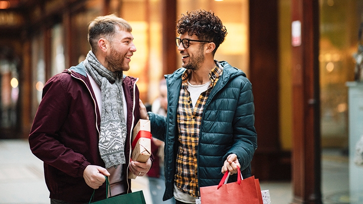 Two men talking and holding holiday gifts