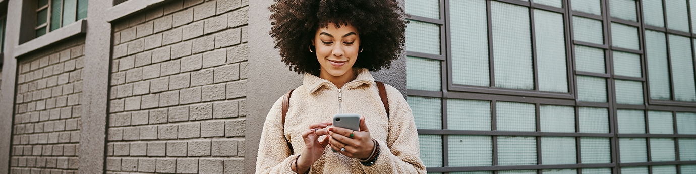 A young woman using WaFd Bank mobile app on her mobile phone.