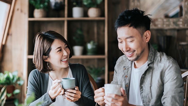 Happy young couple having a coffee date in cafe, drinking coffee and chatting