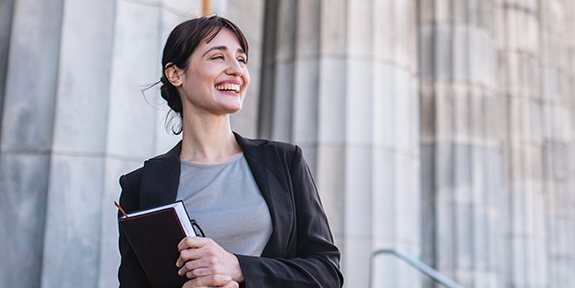 Businesswoman standing in front of government building columns 