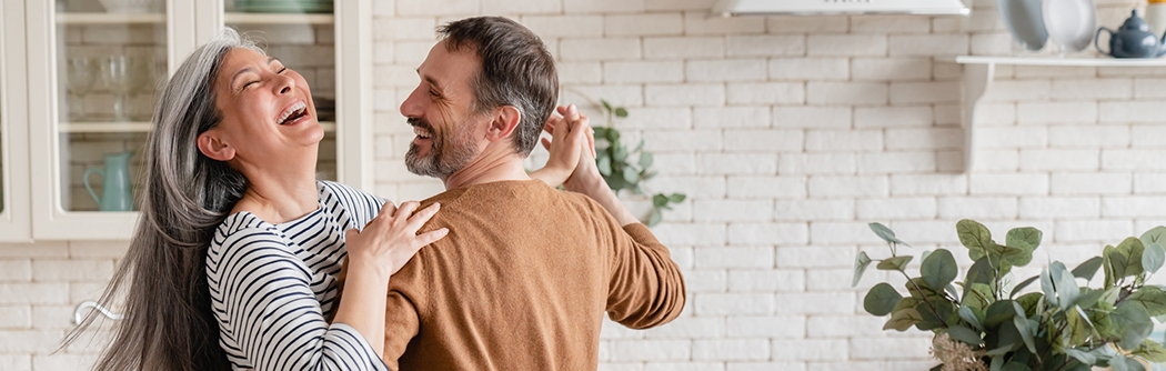 Feliz pareja bailando juntos en la cocina.