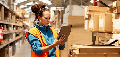 Woman using a tablet in a warehouse.