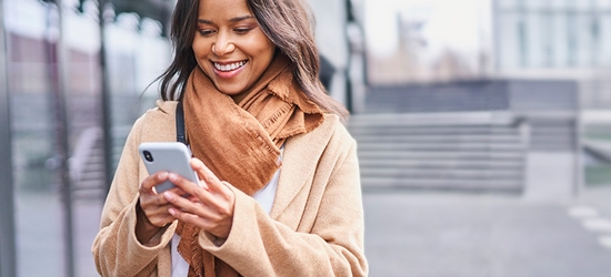 Woman walking outside while on a mobile phone.