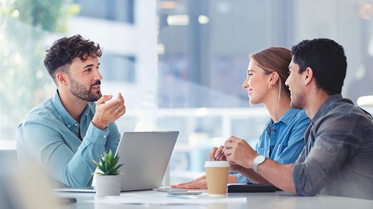 Financial advisor talking with couple in office.