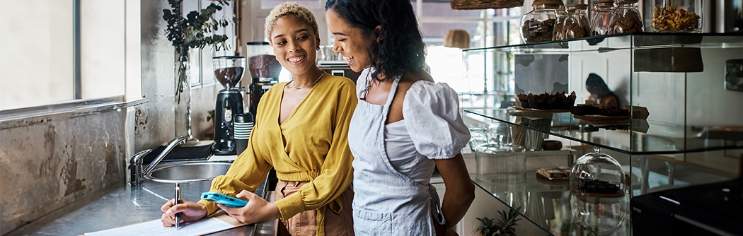 Business owner and employee in a shop reviewing financials.