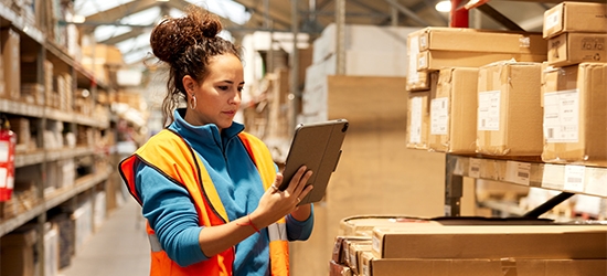 Woman using a tablet in a warehouse.