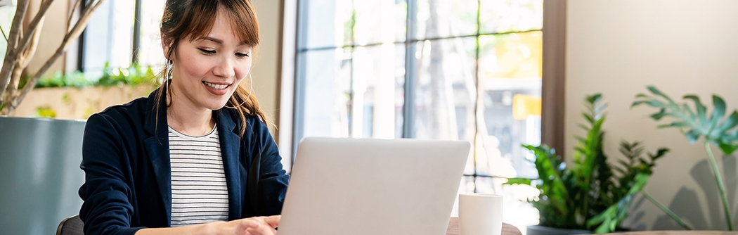 Businesswoman working on laptop at office desk.
