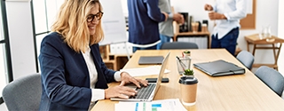 Woman working on laptop in an office.