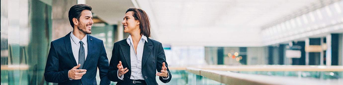 Two business people walking and talking in an office building